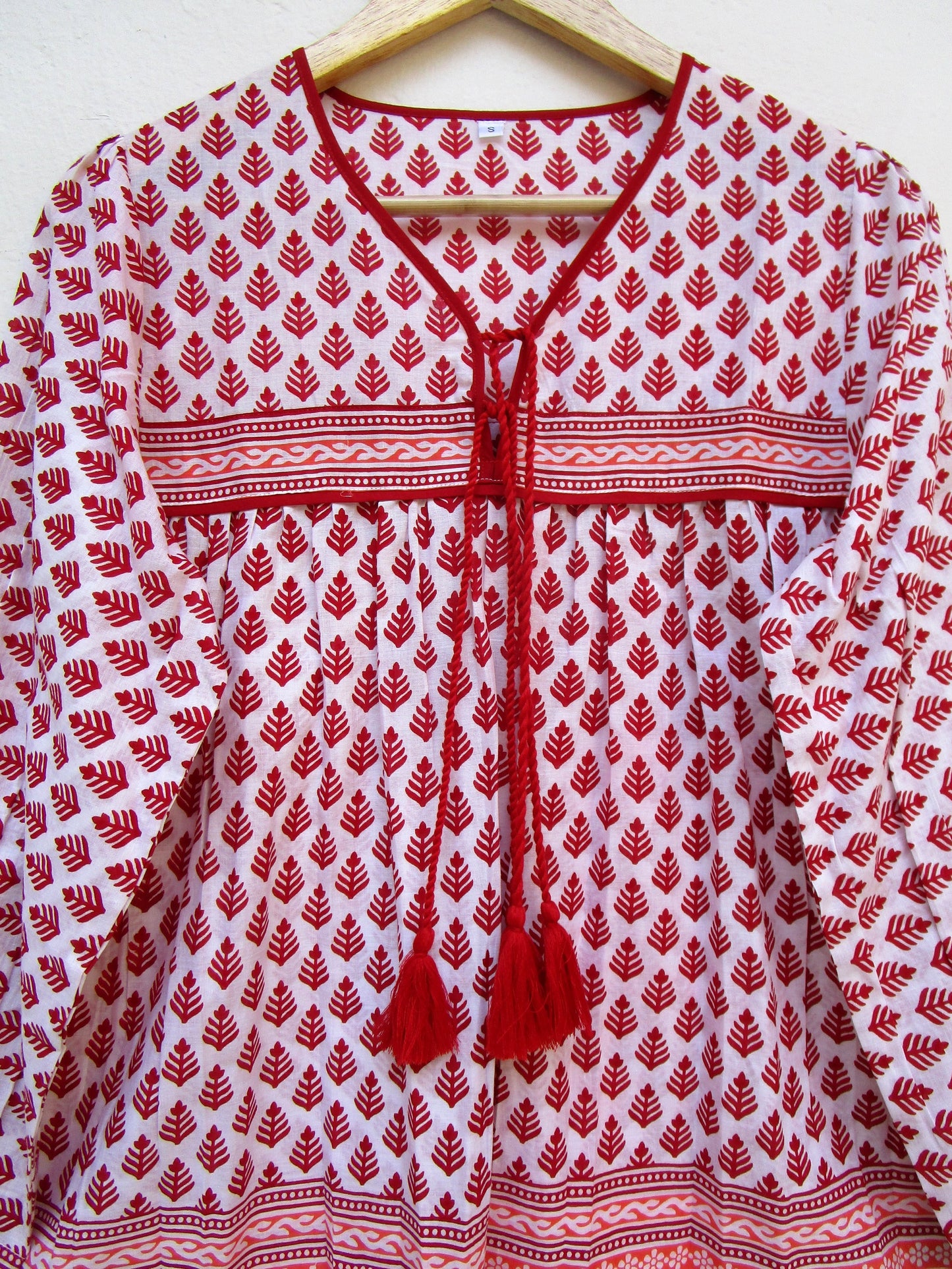 red and white blouse with tassels and a paisley border