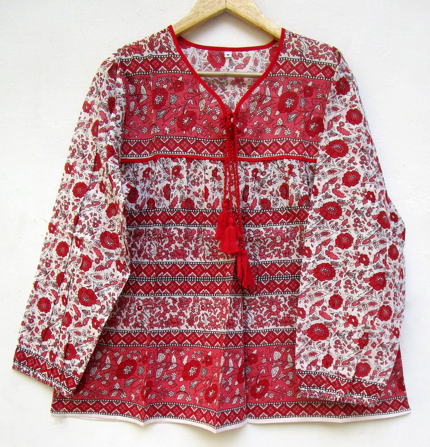 red and white screen printed blouse with long sleeves and tassels