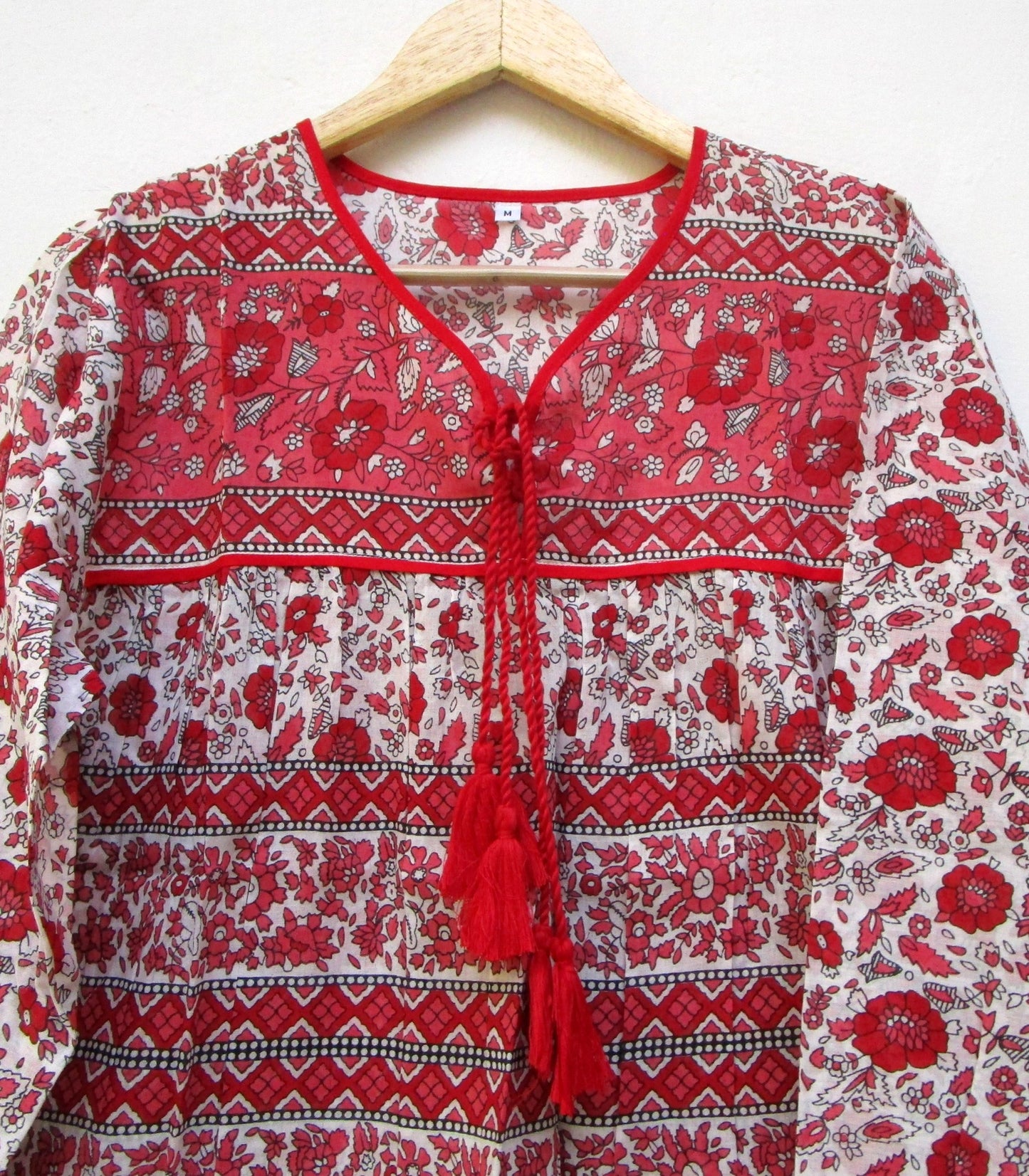red and white screen printed blouse with long sleeves and tassels
