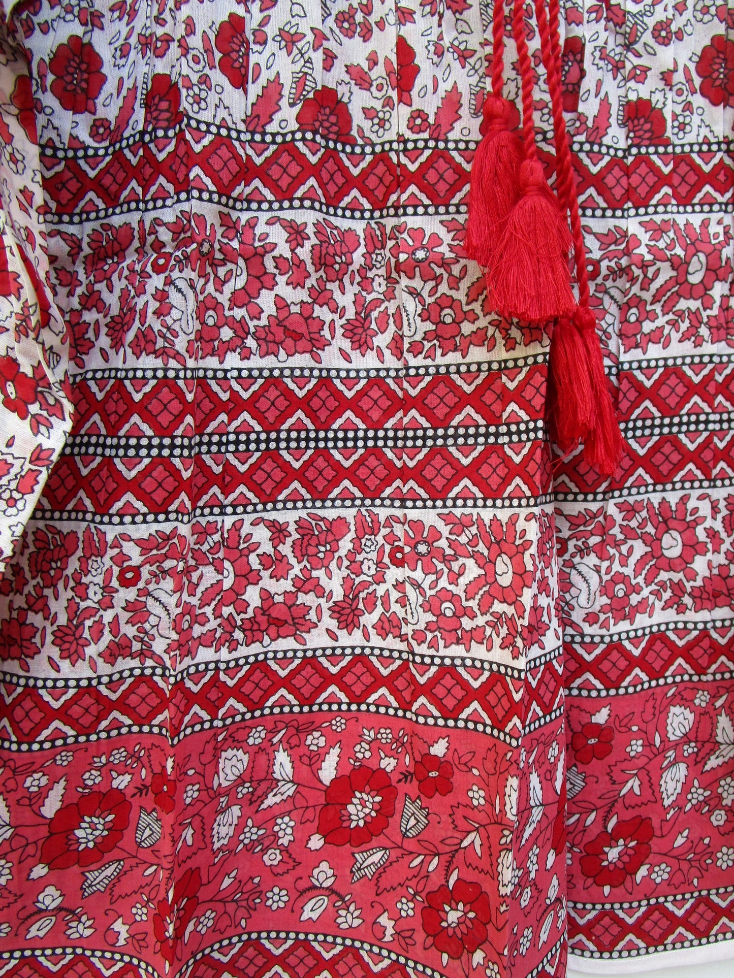red and white screen printed blouse with long sleeves and tassels