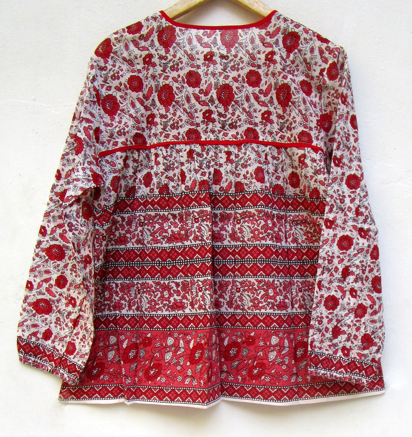 red and white screen printed blouse with long sleeves and tassels
